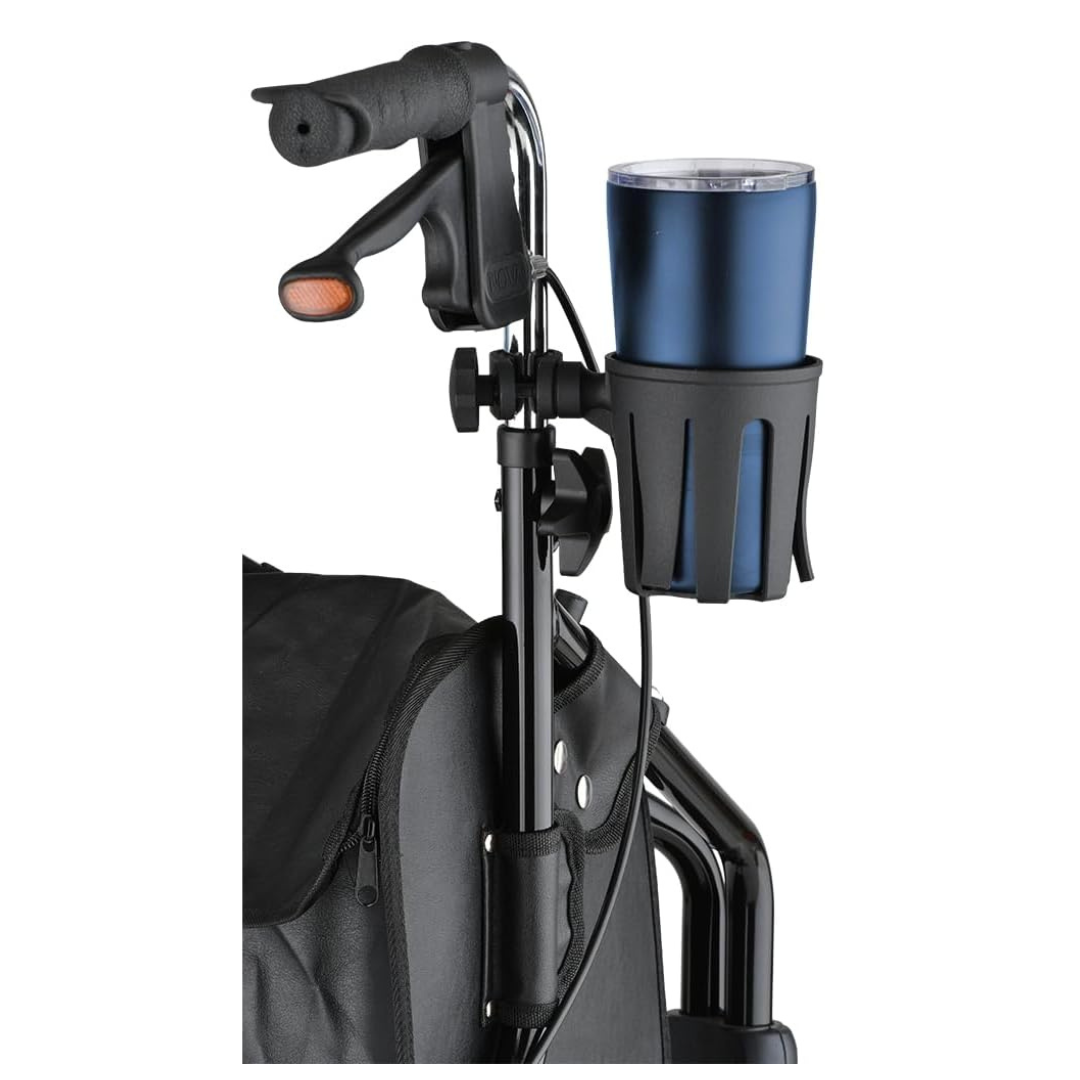 Close-up of a wheelchair handlebar fitted with the Nova Medical Cup Holder for Walkers with Round Narrow Tubing, holding a blue travel tumbler. A brake lever and part of the wheelchair seat are visible in the background.